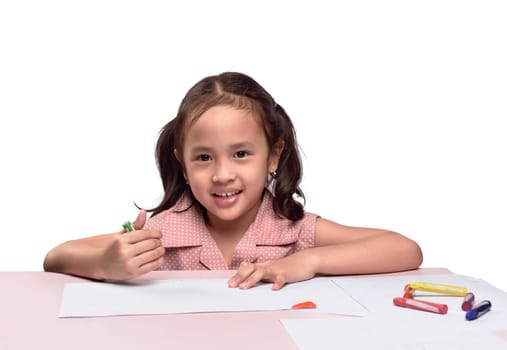 Portrait of lovely asian girl drawing with colorful crayon isolated over white background