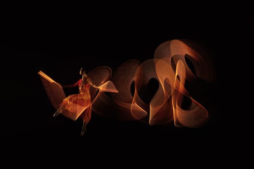 Portrait of ballerina dancer with lights effect over black background