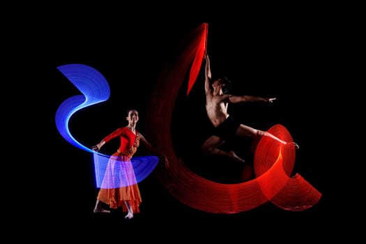 Attractive couple ballet dancer with colorful lights effect against black background