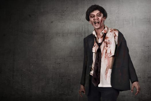Portrait of asian zombies man with wounded face against dark wall background