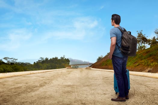 Portrait of asian traveler standing with suitcase enjoying panorama view