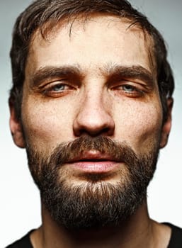 The sad man - the face closeup on studio background