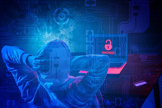 Hooded computer hacker stealing information with laptop. Concept of threat