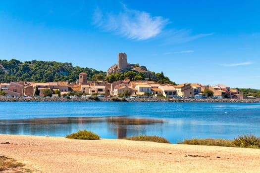 View of the village of Gruissan with the castle ruin Tour Barberousse and the water Etang de Gruissan in the south of France.