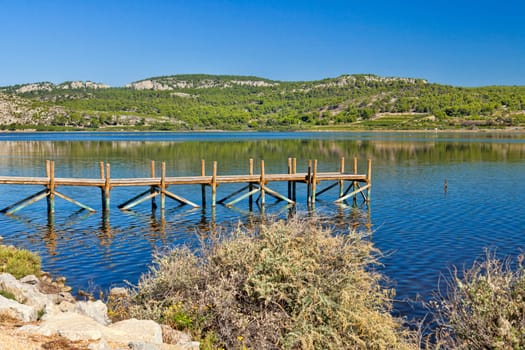 Panorama from the large pond "Etang de Gruissan"" with a wooden walk-in near the village of Gruissan on the Mediterranean coast in the south of France."