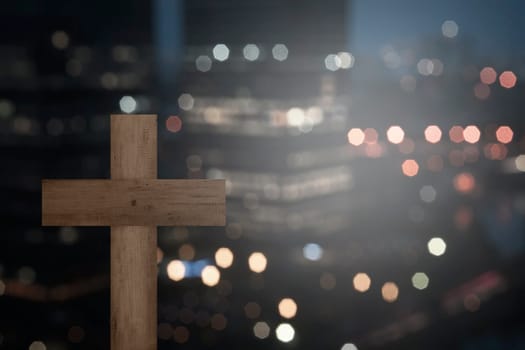 Christian cross with blurry city at night