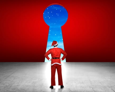 Young asian man wearing santa claus costume looking big key hole