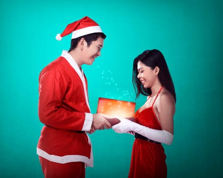 Man in santa claus costume give present box to woman. Christmas concept