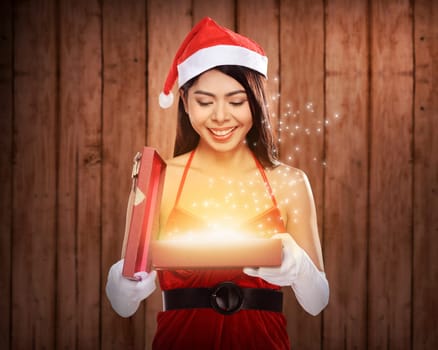Beautiful smiling christmas santa woman wearing santa claus costume opening gift box