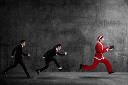 Business people chasing santa claus. Christmas bonus concept