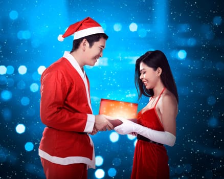 Man in santa claus costume give present box to woman. Christmas concept