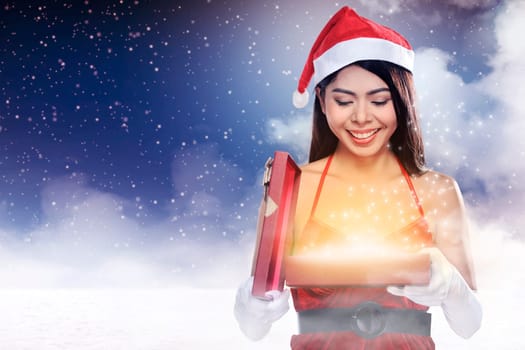 Beautiful smiling christmas santa woman wearing santa claus costume opening gift box