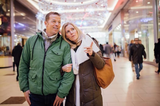 A couple trying to find something new for a christmas presents at a shopping centre.