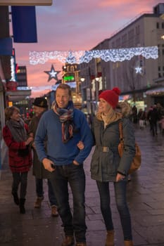 Mature couple are enjoying some winter shopping on an evening at christmas time.