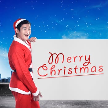 Asian man wearing santa claus costume holding banner with merry christmas writing