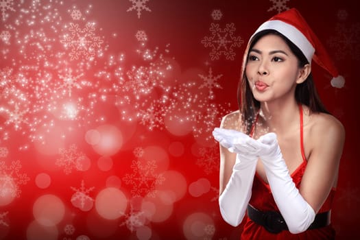 Asian woman in santa claus costume blowing magic dust. Christmas concept