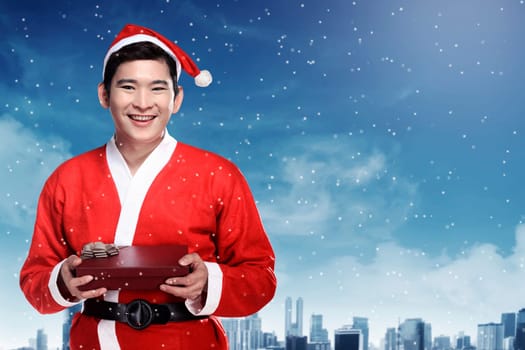 Asian man wearing santa claus costume holding gift box. Christmas concept