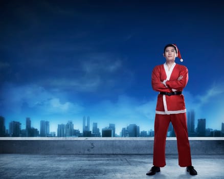 Asian man in santa claus costume standing on rooftop. Merry christmas concept