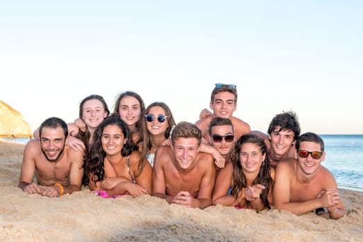 Group of happy teenage friends having fun at the beach