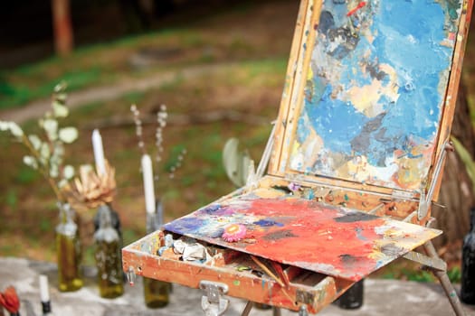 The tools of the artist - paints and brushes on forest background