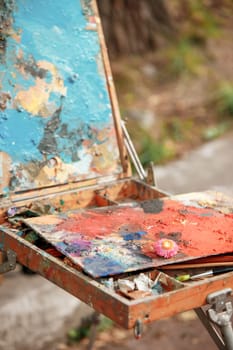 The tools of the artist - paints and brushes on forest background