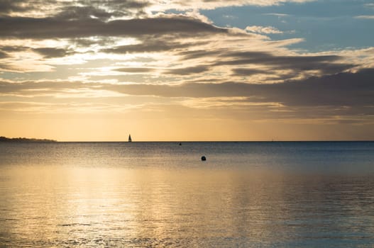 Beautiful sunrise in the summer over silent glossy sea And clouds in the sky . Panorama