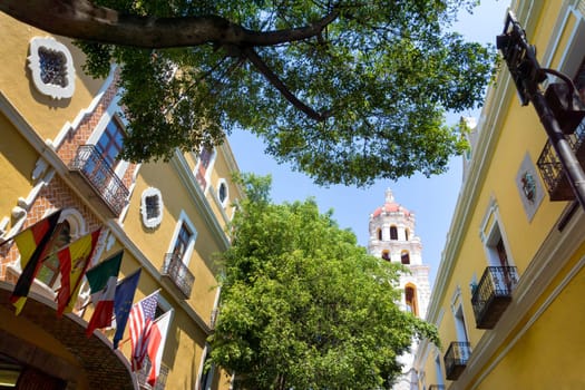 View of yellow colonial building with church in Puebla, Mexico