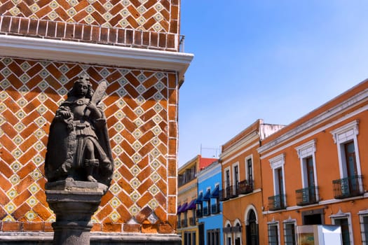 Statue with colonial houses in street in downtown Puebla, Mexico