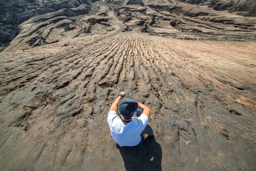 Man on top of Layer Volcanic ash as sand ground of Mount Bromo volcano (Gunung Bromo) at Bromo Tengger Semeru National Park, East Java, Indonesia.