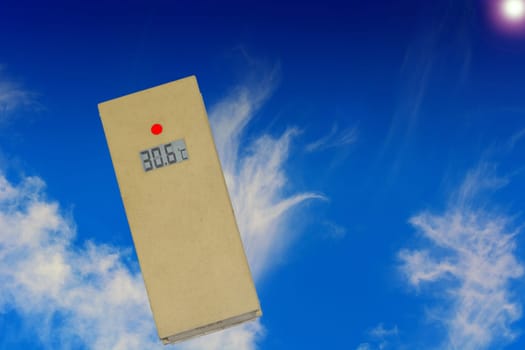 Thermometer in the sun shows 30 degrees. Concept hot summer day and high outside temperatures in front of a blue sky..
