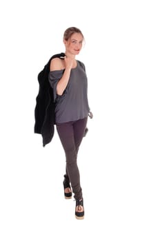 A slim young woman in gray shirt with her jacket over her shoulder and .smiling,  is ready for a walk, isolated for white background.