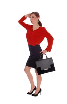 A gorgeous young business woman walking in a red blouse and black .skirt, holding her black purse, isolated for white background.