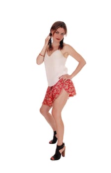 A beautiful young woman standing from the front, lifting up her shorts.smiling, standing isolated for over white background..