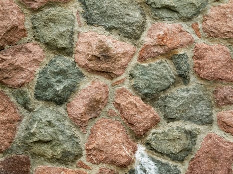 Format-filling view of a brick field-stone wall with cement joints.