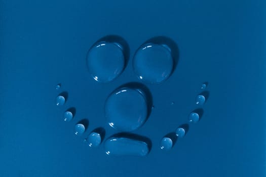 Smiling face made of waterdrops on a blue background