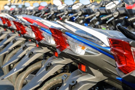 New motorcycles lined up at a store with close up on taillight, transportation background