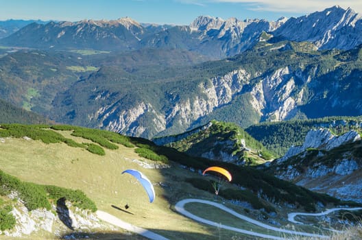 Pair paraplanes launching and soaring in Bavarian Alps mountains. Stock photo with aerial view on Alpine landscape.