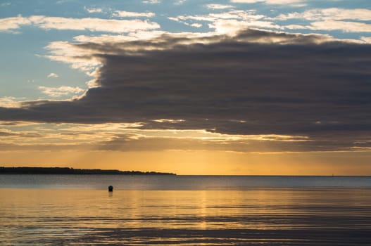 Beautiful sunrise in the summer over silent glossy sea And clouds in the sky . Panorama