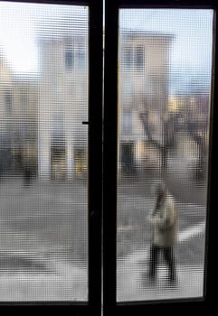 Person out of the old window. Blurred aged photo. Faded colors.