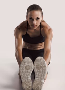 Shot of a young woman doing stretching exercises