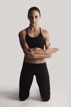 Shot of a young woman doing stretching exercises