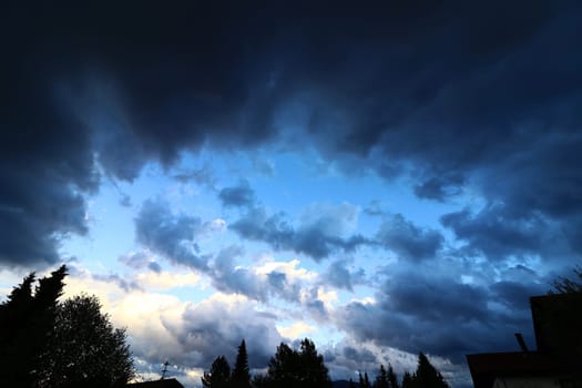 Dark thunderclouds are brewing over a city. Dark rain clouds in the sky