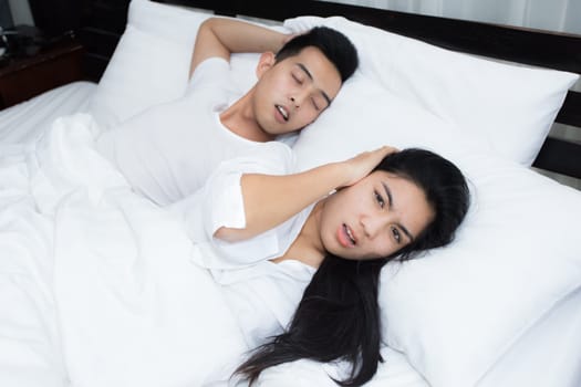 Couple using smartphone on the bed in the morning, smile