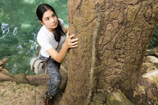 Young asian woman near public board with map, routes and locations