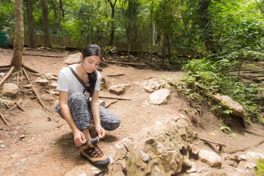 Young asian woman near public board with map, routes and locations