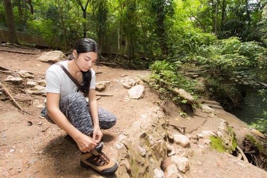 Young asian woman near public board with map, routes and locations