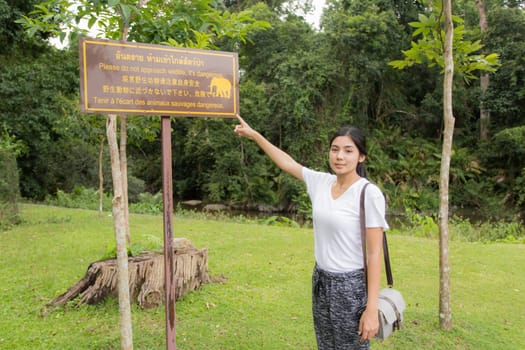 Young asian woman near public board with map, routes and locations