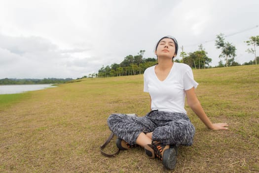 Beautiful smiling young asian woman enjoying yoga, relaxing, feeling alive, breathing fresh air, got freedom from work