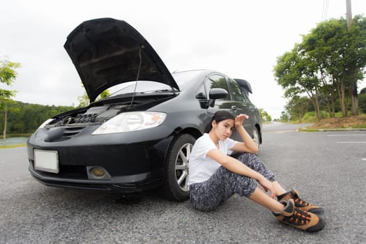 Woman opened the hood Broken car on the side See engines that are damaged or not
