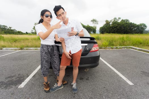 Couple after a car breakdown at the side of the road, woman take a phoen for emergency team